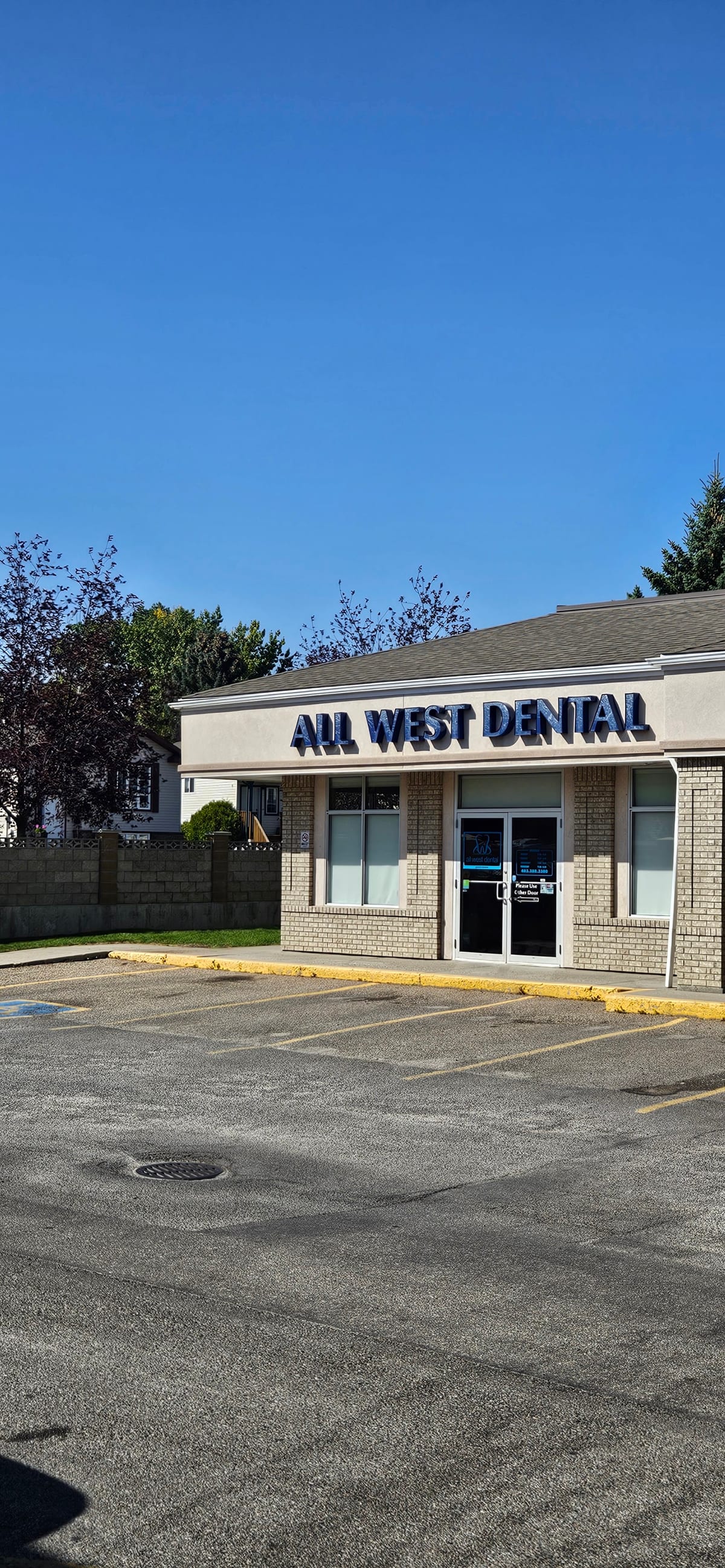 All West Dental's single-storey building seen from its parking lot on a clear day