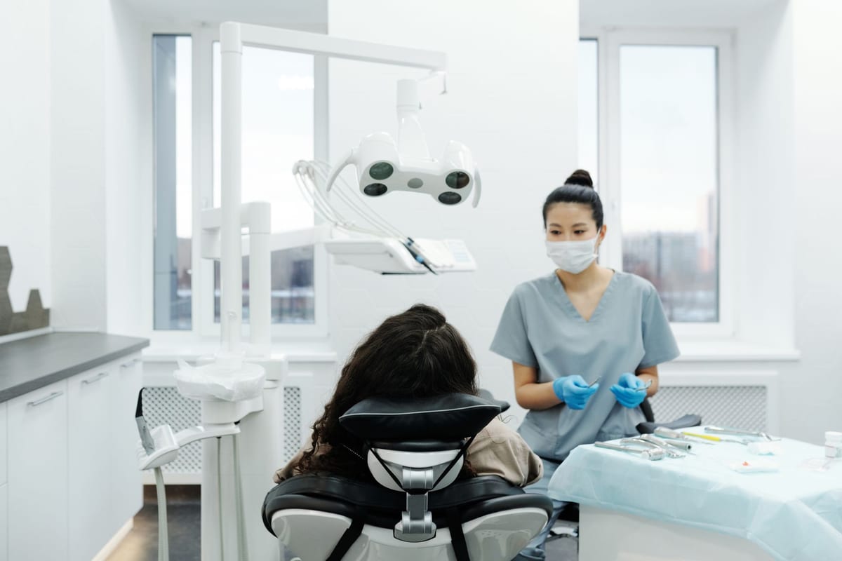 A clinician preparing a restoration at the chairside in a bright treatment room